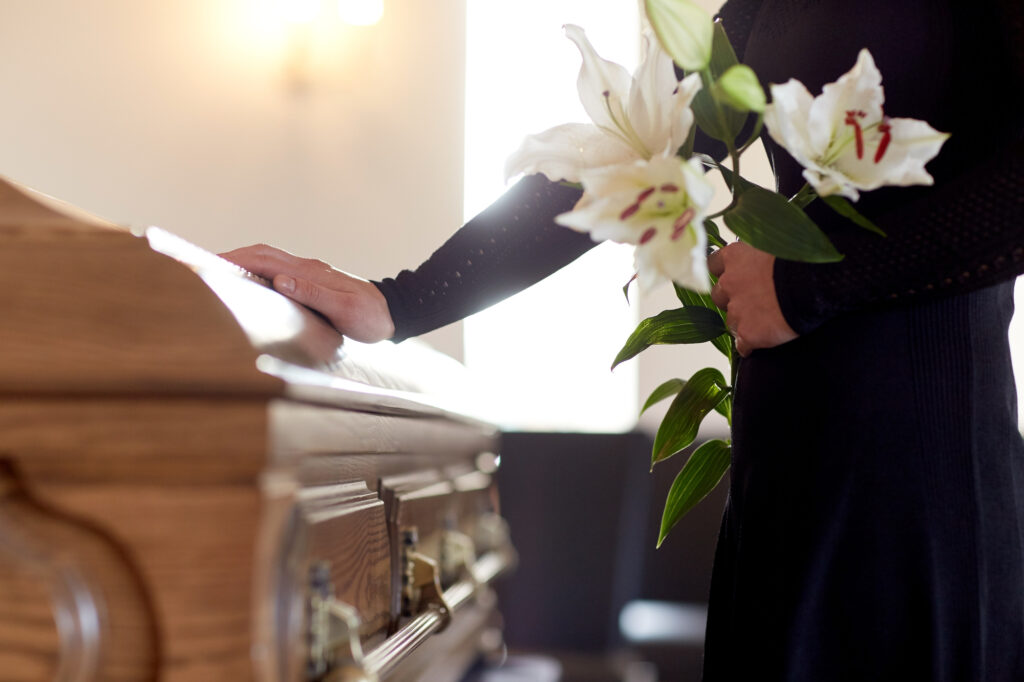 Pre-Planning Funerals: Why It’s Essential And How To Get Started 1 woman with lily flowers and coffin at funeral