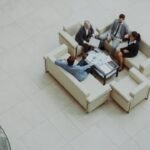 High-angle view of professional business owners collaborating in a modern office lounge to improve operational efficiency.