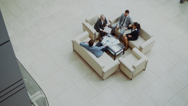 How to Boost Business Efficiency: A Guide for Experienced Business Owners 1 High-angle view of professional business owners collaborating in a modern office lounge to improve operational efficiency.